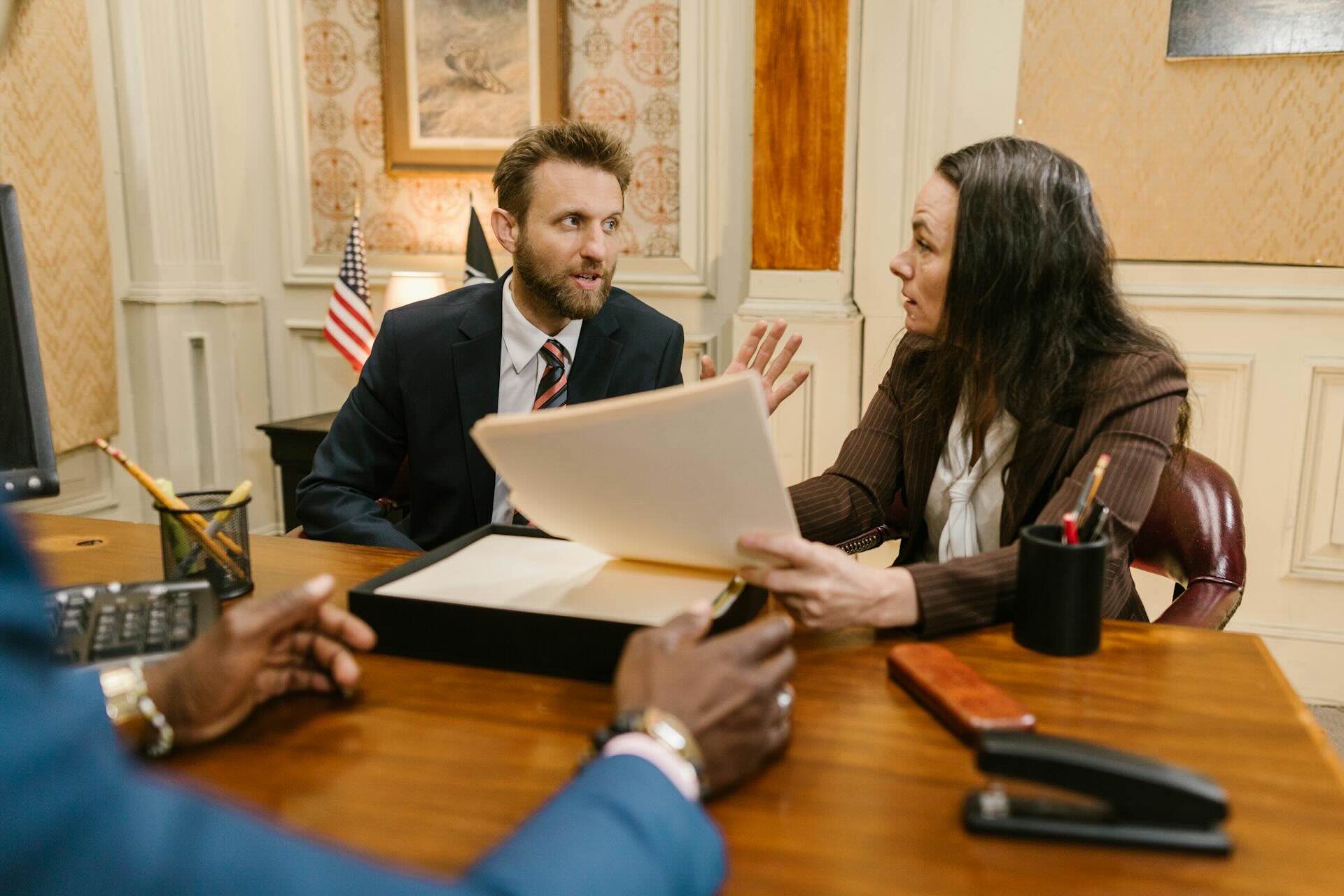 Immigration attorney consulting with specialist reviewing PERM recruitment advertising compliance documentationdocumentation